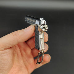 Small model gun held in a hand against a dark background
