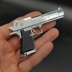 Metallic handgun model held in a hand against a dark background