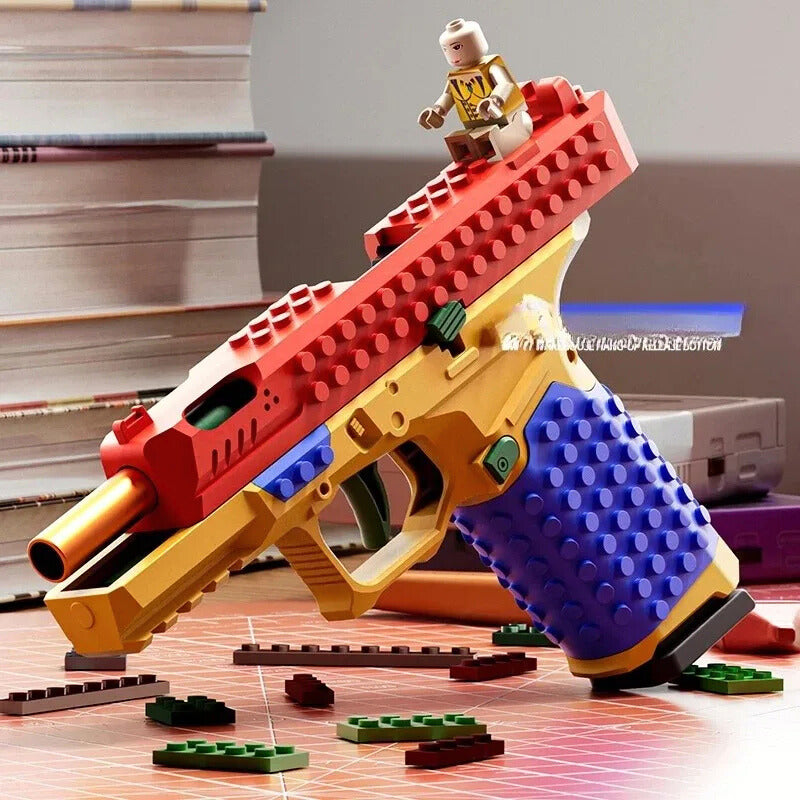 Toy gun made of interlocking bricks with a minifigure on top, set against a blurred indoor background.