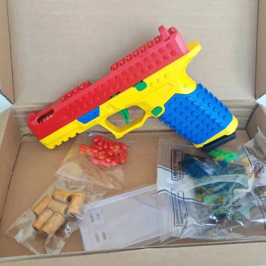 Colorful toy gun with accessories on a cardboard box