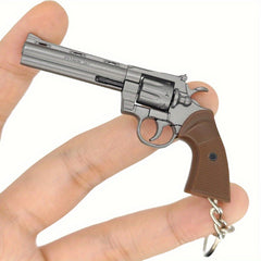Keychain revolver held in a hand against a white background
