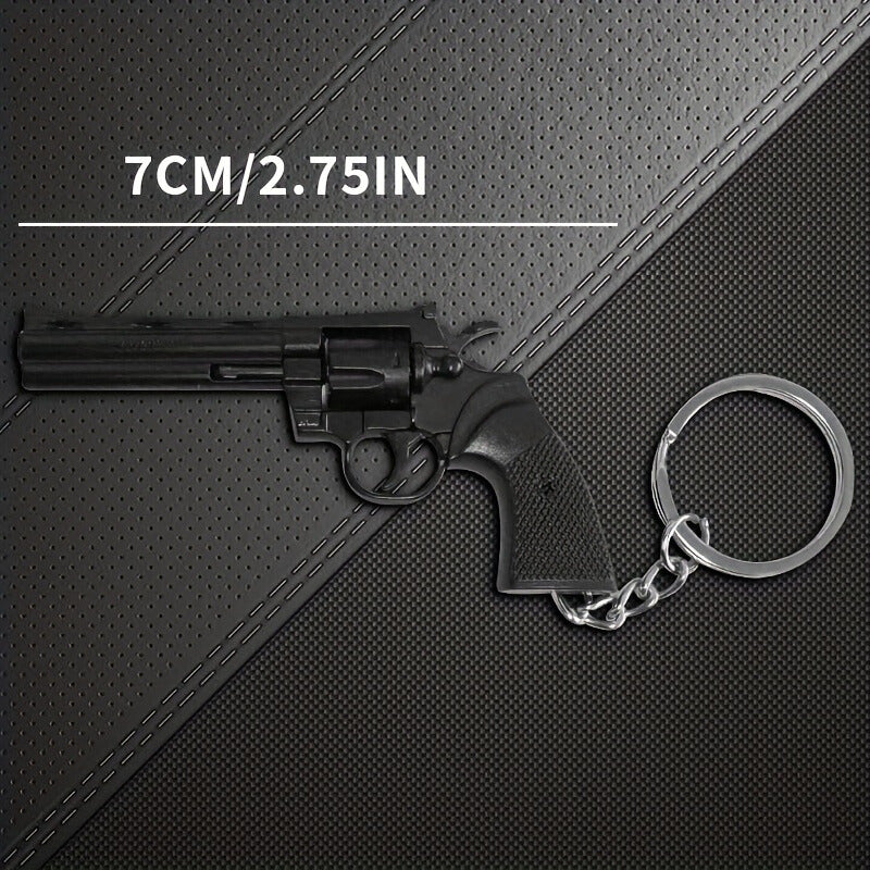 Black revolver-shaped keychain on a textured black surface with measurement text.