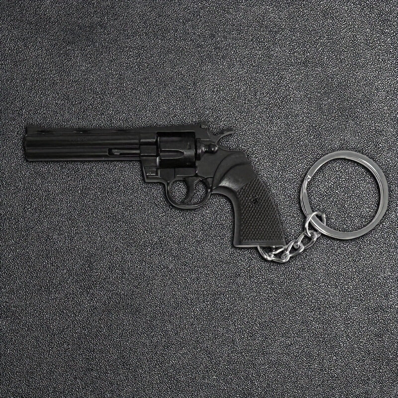 Revolver-shaped keychain on a textured gray surface
